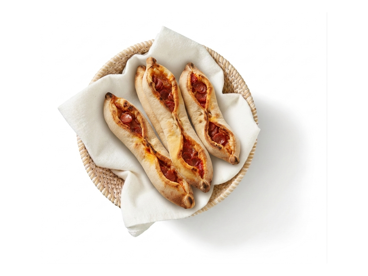 Drie versgebakken pepperoni pide broodjes in een gevlochten mandje.