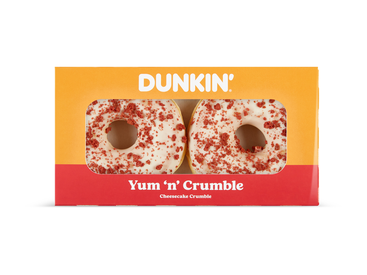 Twee donuts met witte glazuur en rode kruimels in een oranje en rood doosje met de tekst 'Yum 'n' Crumble Cheesecake Crumble'.