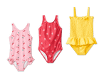 Drei Kinderbadeanzüge: ein rosafarbener mit Kirschen, ein roter mit Erdbeeren und ein gelber mit Rüschen.