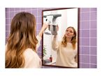 Woman cleaning a bathroom mirror with a window vacuum cleaner.