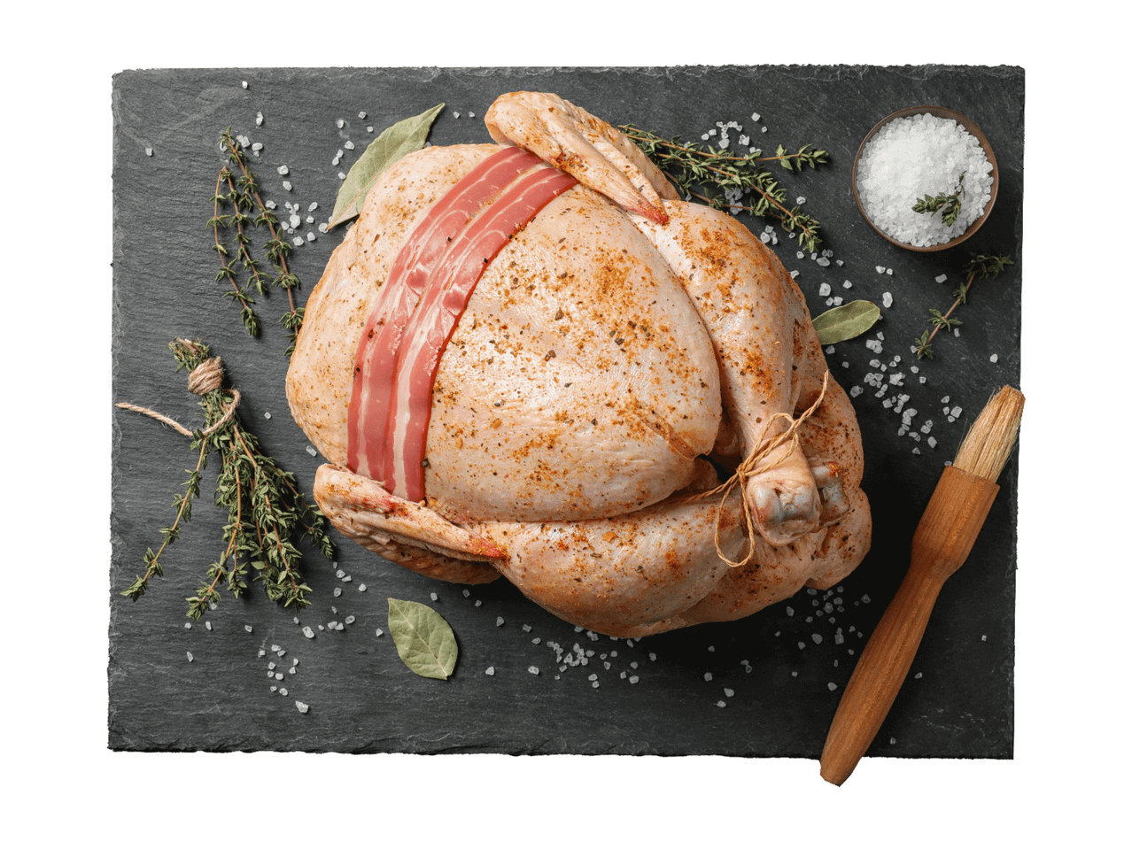 Toores kana, maitsestatud vürtside ja peekoniga, mustal laual ürtide ja soolaga.