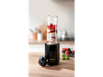 A SilverCrest personal blender sits on a wooden counter with fresh berries nearby, ready to make a smoothie.