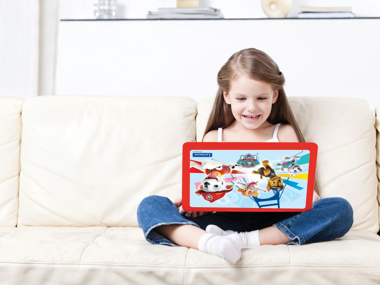 Момиче седи на диван, гледайки таблет Paw Patrol Lexibook.