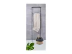 Black metal towel ladder with a beige towel, a woven basket, and a green plant.