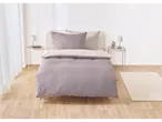 A mauve and beige patterned duvet cover set on a bed.