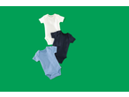 Three baby bodysuits in white, navy, and light blue, arranged diagonally on a green background.