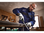 A man in work clothes and safety glasses using a PARKSIDE® File Set on a metal sheet.