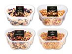 Fire beholdere med forskellige snackblandinger: sødt og salt, nødder og frugt, hot snack mix og pubmix.