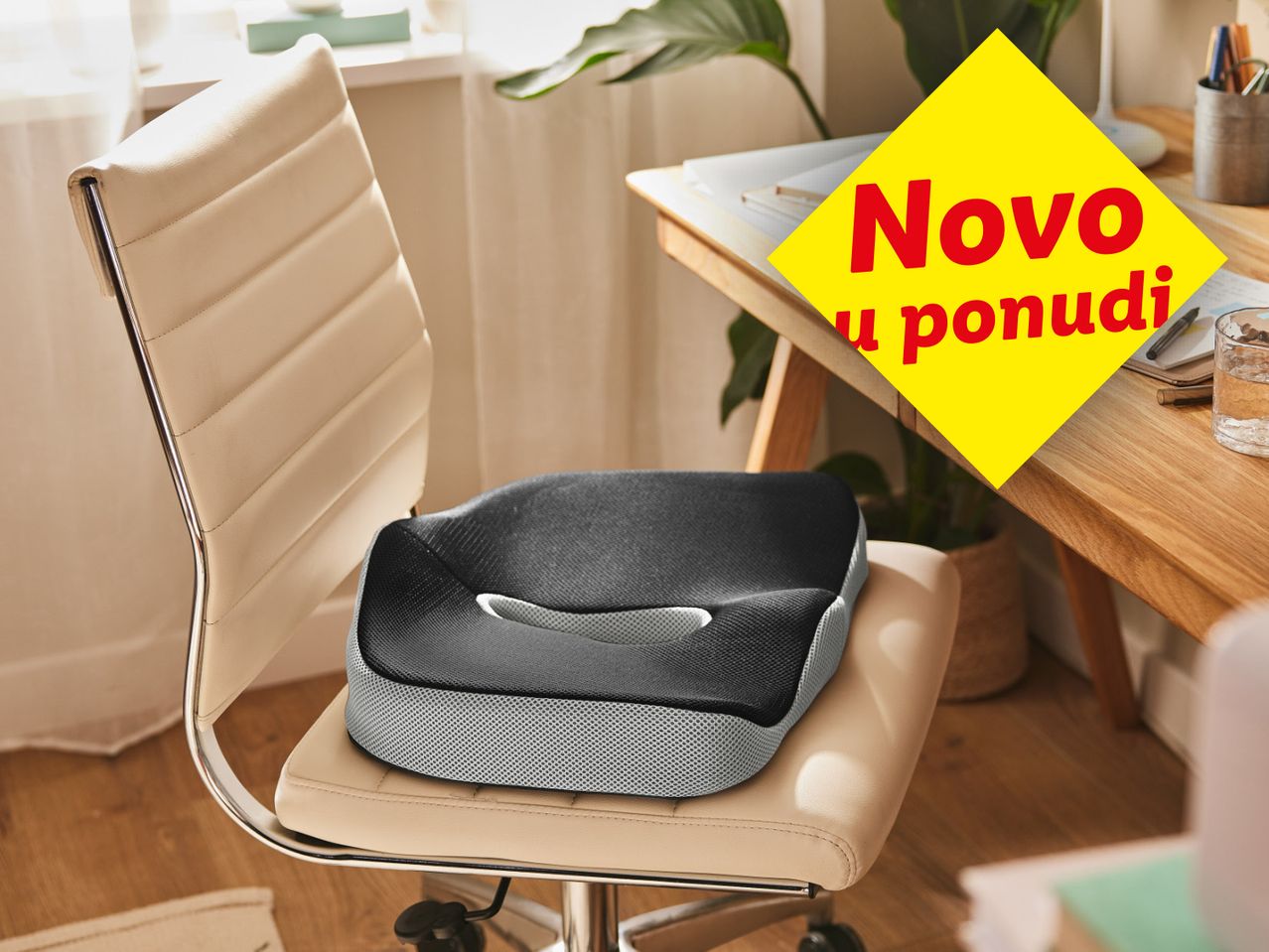 Ergonomski jastuk za sjedenje na bež uredskoj stolici s natpisom 'Novo u ponudi'.