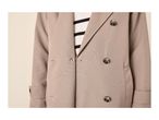 Close-up of a beige double-breasted trench coat with a striped shirt underneath.