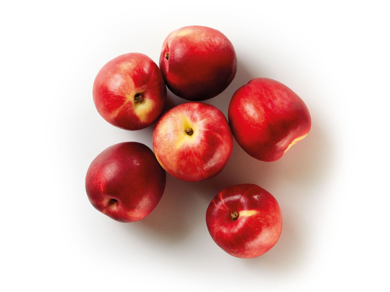 Sei pesche rosse mature su sfondo bianco.
