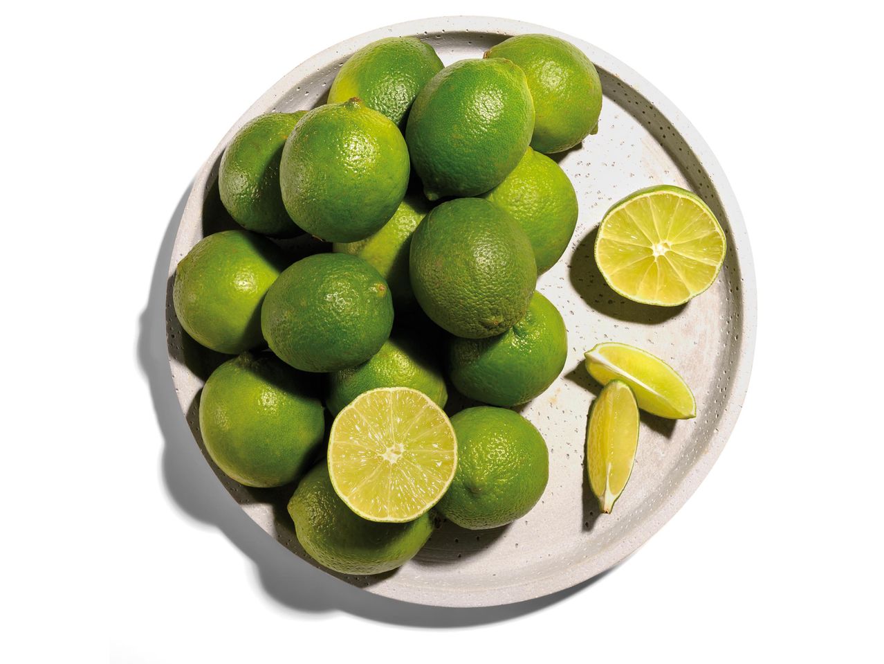 Egy tányéron lévő friss lime-ok.