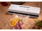 Máquina de vácuo Silvercrest com carne marinada e citrinos num saco.