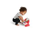Toddler playing with a colorful toy piano with sheet music showing a giraffe.