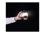 Hand holding a black and orange camping lantern with a bright white light