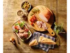 Mortadella, salade en brood op een rustieke houten tafel.