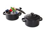 Two black ceramic mini casseroles, one with a chocolate dessert and berries, the other with a lid.