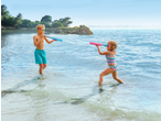 Zwei Kinder spielen mit HAPPY PEOPLE Wasserpistolen im Meer.