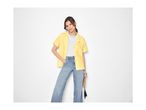 Woman in a yellow short-sleeved shirt, white t-shirt, and light blue jeans.