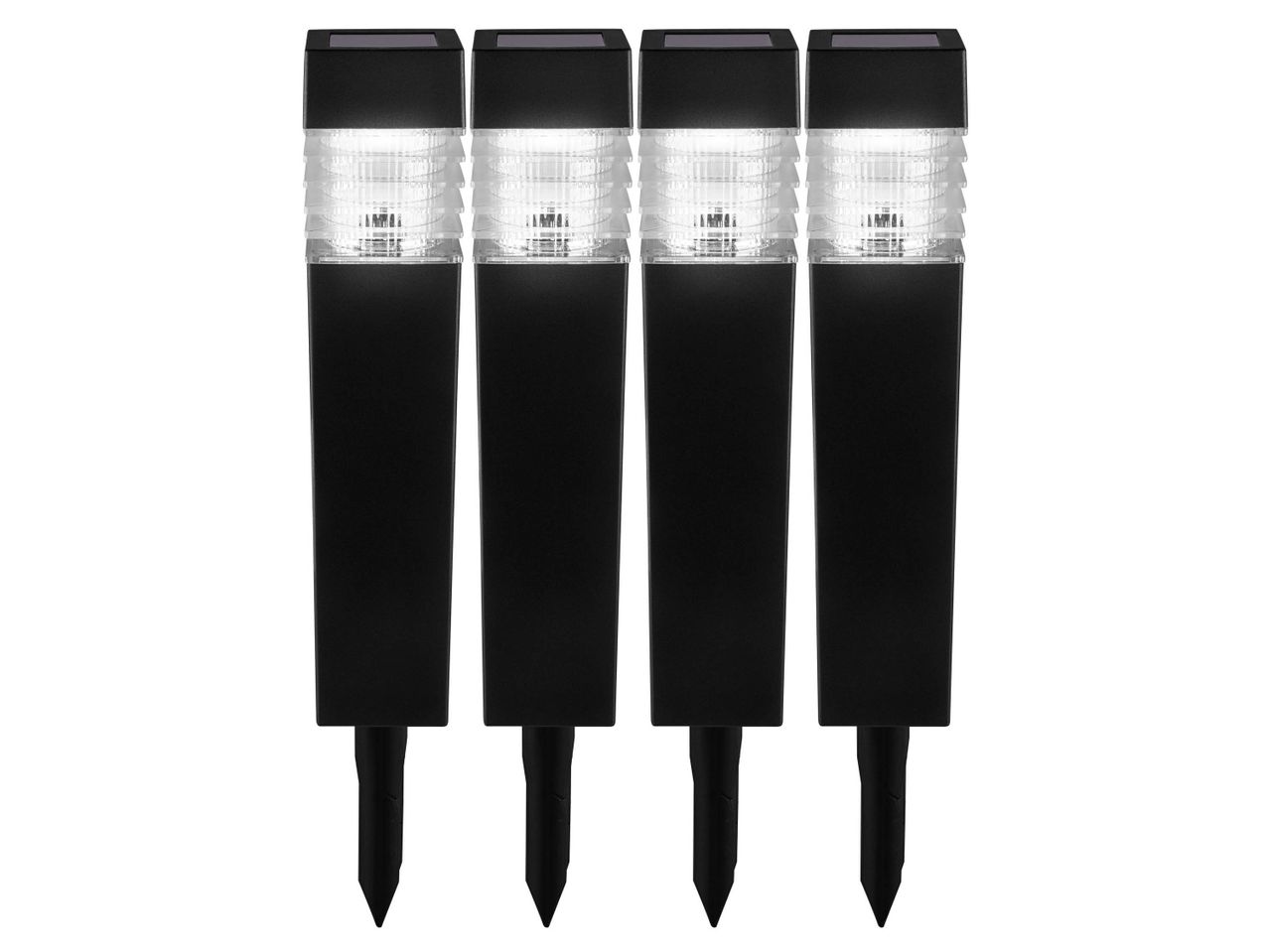 Four black solar-powered garden lights with clear ribbed tops and ground stakes.