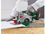Cortador de azulejos sem fio Parkside 20 V a cortar um azulejo branco com luvas de trabalho.