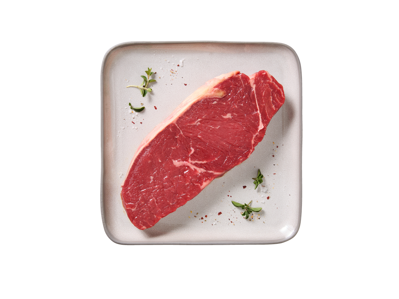 Šviežias DELUXE Angus Rib Eye kepsnys su žolelėmis ir prieskoniais lėkštėje.