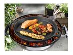 Grill pan with salmon, chicken skewer, vegetables, and shrimp on a charcoal grill.