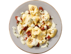 Tortellini met blauwschimmelkaas saus en gedroogde tomaten op een bord.