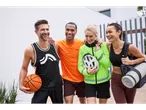 Patru prieteni zâmbesc purtând haine și echipament sportiv.