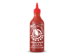 Een fles hete sriracha chilisaus met een rode dop tegen een zwarte achtergrond.
