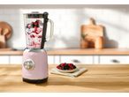 Liquidificador Silvercrest rosa com frutas em uma mesa de madeira.