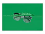 Sunglasses partially submerged in green water with splashes.