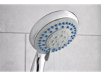 Chrome shower head with blue nozzles, wall-mounted.