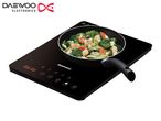 Daewoo single-burner portable induction cooktop with a frying pan cooking stir-fried vegetables.