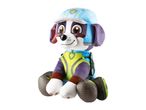 Plush toy dog wearing a blue cap and a green and yellow vest, sitting.