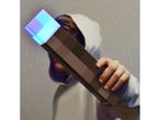 Una persona tiene in mano una torcia Minecraft illuminata.