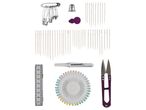 A collection of sewing tools including safety pins, needles, a thimble, a measuring tape, and scissors.