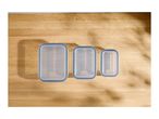 Three rectangular food storage containers with blue seals on a wooden surface.