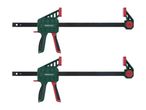 Two green and red bar clamps with black bars, used for woodworking or DIY projects.