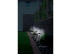 Solar-powered garden lights illuminating a stone wall and pathway at night.