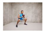 Man squatting with a kettlebell.