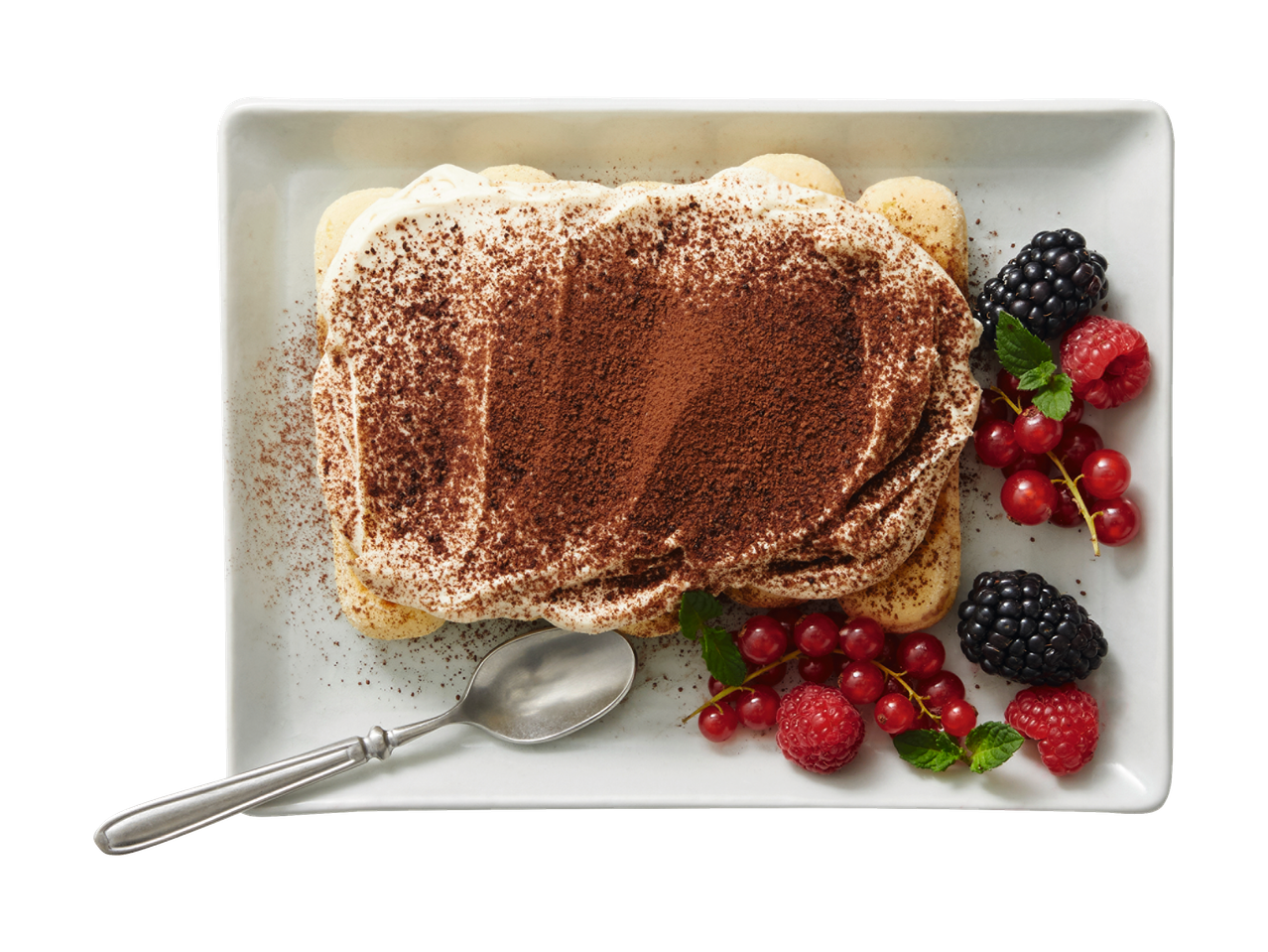 Tiramisu met frambozen en braambessen op een wit bord.