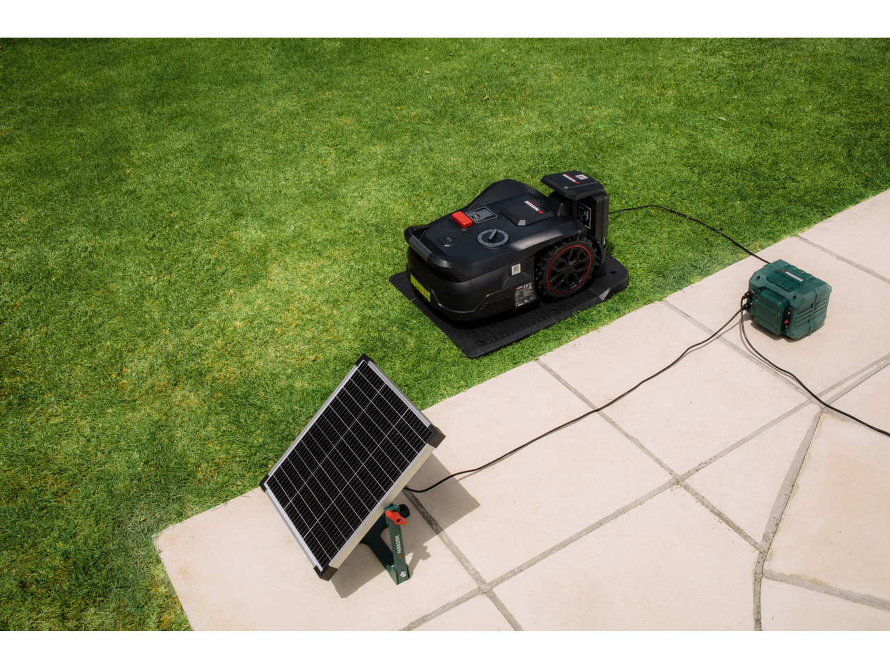 Robot de tuns iarba PARKSIDE PERFORMANCE cu panou solar și stație de încărcare în grădină.