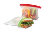 Reusable food storage bags, one with a sandwich and another with vegetables.
