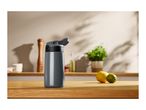 Grey water bottle on a wooden kitchen counter with lemons and limes.