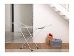 White clothes drying rack in a modern home with a laundry basket and candles.