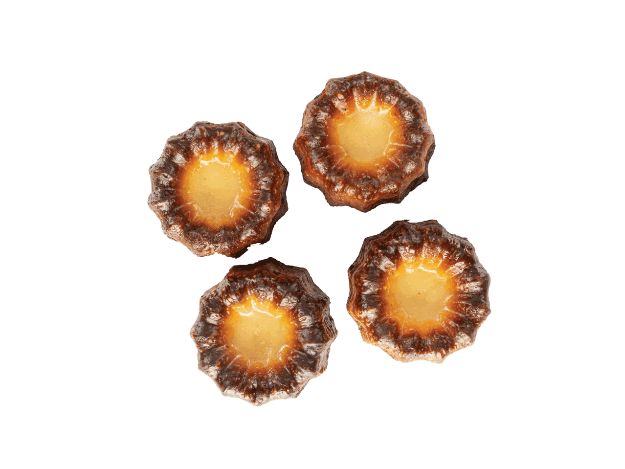 Keturi auksiniai canelés pyragaičiai su karamelizuota plutele, išdėstyti apskritimu.