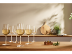 Pahare de vin alb pe o masă din lemn, alături de măsline și rozmarin.