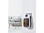 TRONIC® 600W Ceramic Plug Heater plugged into a wall socket, heating a living room.