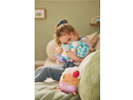 Happy child hugging two plush toys, with another plush toy nearby on a green blanket.